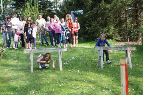Eltern und Kinder haben im Freien Spaß beim Eierlaufen