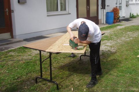 Junge beim Aussägen einer Form aus der Holzplatte