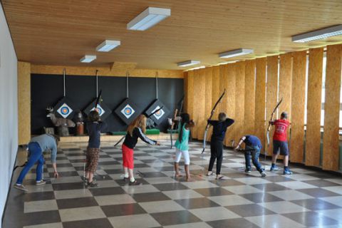Gruppe Jugendlicher und Kinder beim Workshop Bogenschießen